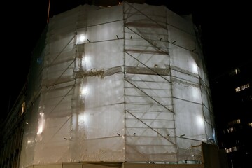 a scaffold wrapped in foil that is illuminated from the inside at night