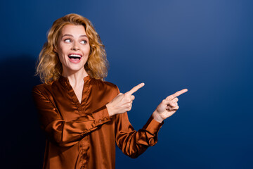 Wall Mural - Portrait of overjoyed girl with curly hairdo wear silk blouse indicating look at sale empty space isolated on dark blue color background