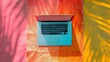 © zai - Laptop on colorful beach towel with vibrant lighting