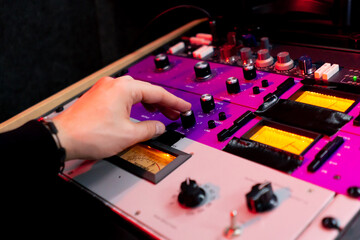 in the recording room under neon lighting professional remote control for adjusting the sound the director turns on the toggle switch on the amp