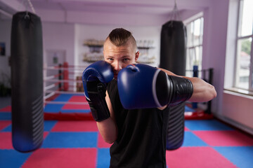 Wall Mural - Young boxer doing shadow boxing in a gym