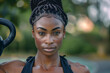 © Evan - Portrait of a fit black sportswoman with kettlebell in her hands looking at the camera.