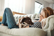 © peopleimages.com - Dog, couch or happy woman in home to relax on living room sofa in house, lounge or apartment. English spaniel puppy, hug or person resting with love, wellness or support for bonding with pet animal