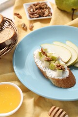 Wall Mural - Delicious ricotta bruschetta with pear and walnut served on table, closeup