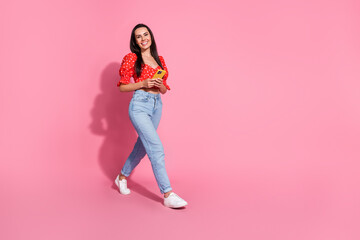 Sticker - Photo portrait of brunette hair hispanic young smiling lady in bright red stylish blouse using smartphone walking isolated on pink color background