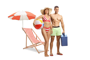 Wall Mural - Young couple in swimming suits standing in front of a beach chair