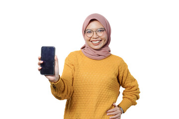 Wall Mural - Smiling young Asian Muslim woman dressed in casual sweater showing blank screen mobile phone