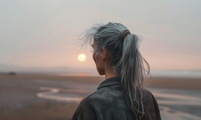 Wall Mural - A woman with grey hair looking at the sea coastline