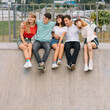 © anatoliycherkas - Summer holidays and teenage concept - group of smiling teenagers hanging out outside.