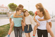 © anatoliycherkas - Group of teenagers school friends having fun piggybacking outdoors