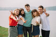 © anatoliycherkas - Summer holidays and teenage concept - group of smiling teenagers hanging out outside.