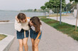 © anatoliycherkas - Two stylish teens schoolgirls joking and smiling togather on the street at school