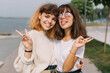 © anatoliycherkas - Two stylish teens schoolgirls joking and smiling togather on the street at school