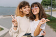 © anatoliycherkas - Two stylish teens schoolgirls joking and smiling togather on the street at school