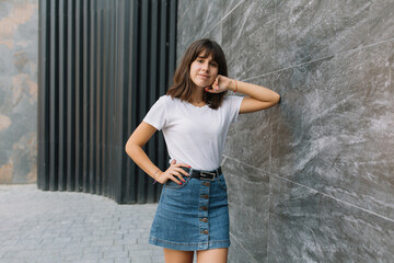 Wall Mural - Pretty teen girl with braces in glasses posing near gray wall