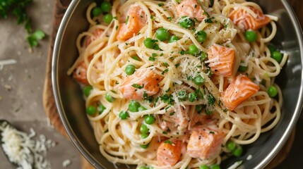 Wall Mural - A rustic seafood pasta dish with al dente spaghetti tossed in a creamy sauce with chunks of salmon, peas, and Parmesan cheese