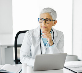 Wall Mural - doctor senior laptop woman medical hospital care health clinic elderly mature caucasian female happy healthcare glasses office confident medicine occupation