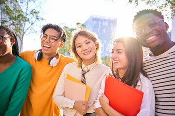 Wall Mural - Asian young student woman standing smiling and posing for photo looking at camera with her multiracial college classmates on university campus. Group of cheerful generation z friends together outdoors