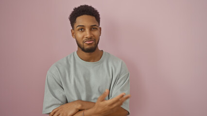 Portrait of a confident young african american man casually dressed standing against a pink background