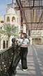 © Krakenimages.com - Young hispanic woman holding a coffee cup while exploring modern architecture in doha, qatar