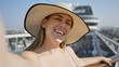 © Krakenimages.com - Joyful woman enjoys a sunny cruise vacation, confidently smiling on the ship's deck overlooking the sea.
