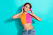 © deagreez - Photo of dreamy pretty woman wear pink orange top closed eyes enjoying music headphones isolated teal color background
