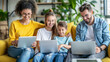 © Ignacio Ferrándiz - A family of four is sitting on a couch, each using a laptop. Scene is happy and relaxed, as the family members are enjoying their time together