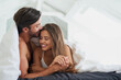 © A.S./peopleimages.com - Couple, forehead kiss and embrace in bed for morning romance, love and bonding on weekend. Relationship, man and woman together in home for comfort, relax or care and resting with partner on break