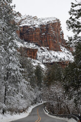 Wall Mural - A road winding through a winder wonderland with the red rock cliffs of Sedona, AZ towering above the road.