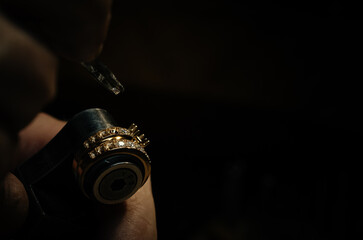 Wall Mural - craftsman making diamond ring. hand made jewelery. Put diamond gem ring. diamond ring production. hand made in craftsman workshop close up. black background.