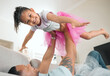 © peopleimages.com - Child, father and airplane on sofa for portrait, fun and bonding in childhood in living room. Happy girl, dad and fantasy at home for flying, support and excited on couch for family games in lounge