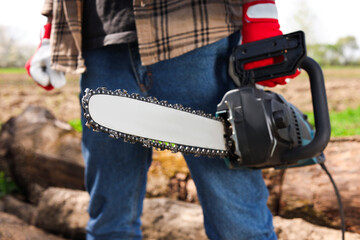 Wall Mural - Man with modern saw on sunny day, closeup