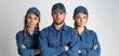 © Nataliia_Trushchenko - Three people wearing blue denim jackets and hats are standing together. man and woman Plumber team standing near to each other back to back isolated on white background
