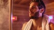© Emiliia - A man with a beard sits in a wooden sauna, relaxing and enjoying the steam.
