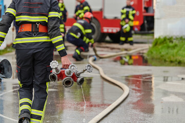 In a dynamic display of synchronized teamwork, firefighters hustle to carry, connect, and deploy firefighting hoses with precision, showcasing their intensive training and readiness for challenging