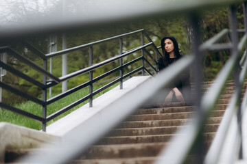 Wall Mural - Smiling woman in sportswear sitting on stairs outdoors