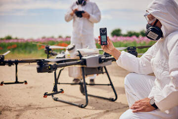 Operator with a protective mask and clothes holding a hand-held anemometer, measuring the air flowing.