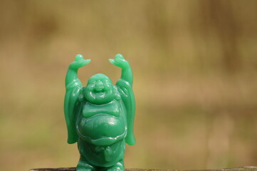 Wall Mural - A figurine of a smiling Buddha. Religious symbols.