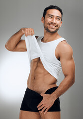 Wall Mural - Man, studio and happy in underwear for fitness with model, athlete and body transformation on grey background. Vest, abs and wellness for muscles on bodybuilder, confident progress and backdrop