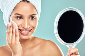 Poster - Woman, cotton pad and towel with mirror in studio for wellness, health and face products. Female person, skincare and cosmetic for results, pride and dermatology for glowing skin in blue background