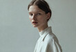© GS-Studio - A young woman with brown hair and light makeup is wearing a white turtleneck blouse and looking at the camera.