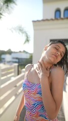 Wall Mural - A woman in a colorful swimsuit has a carefree day at the pool under tropical sunlight