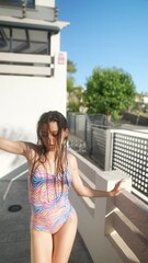 Wall Mural - Young woman in swimsuit enjoying sunny day outdoors, smiling and happy under the sunshine