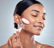 © peopleimages.com - Face roller, beauty and woman in studio for skin care, wellness and product for massage. Female person, hand and cosmetics with results with glow, luxury and lymphatic drainage by white background