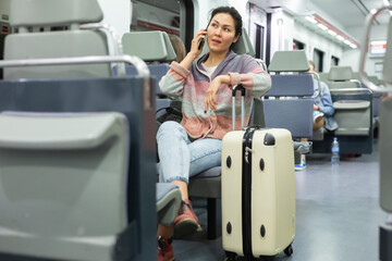 Portrait of woman traveler with backpack and suitcase in subway car