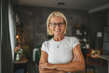 Portrait of relax mature senior woman stand and smile at home