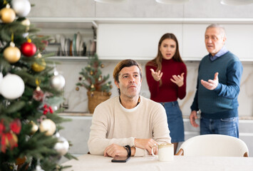 Wall Mural - Elderly man and young woman quarreling with adult man in kitchen at home