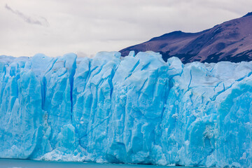 Blu ice glacier Perito Moreno in Patagonia, Argentina. Huge ice seracs wall above the lake on a cloudy nasty day. South America Arcitc landscape on polar latitude. Mountain glacier scenic landscape