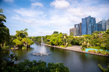 Fresh water from Dragonfly Lake in Gardens by the Bay, Singapore. Green view and a blue sky background.