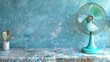 © Aqsa - A turquoise fan on a ceramic tiled kitchen table, creating a cooling breeze in a Mediterranean-style kitchen with ocean-themed decor. Space for text against a sea blue wall.